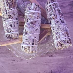 smudge sticks made of sage and palo santo on a wooden table