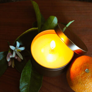 orange blossom candle burning on wooden table