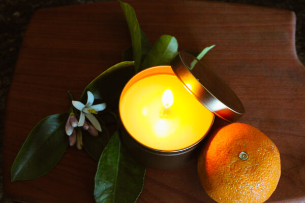 orange blossom candle burning on wooden table